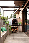 Pizza oven with firewood on wooden terrace