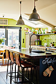 Island counter in kitchen-dining room with green walls