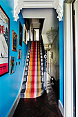 Brightly striped carpet on staircase with bright blue wall