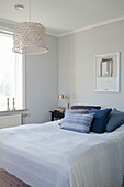 Blue scatter cushions on bed in simple bedroom