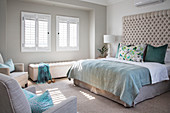 Schlafzimmer in Naturtönen, Doppelbett mit hohem, gepolstertem Betthaupt