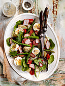 Potato salad with bacon, asparagus, baby spinach and egg