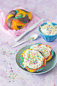 Rainbow bagels with vanilla cream and colorful sugar sprinkles