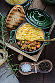 Shepherd's pie in a small cocotte with dark beer and bread