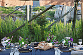 Table set for summer party below wooden frame