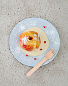 A baked apple with vanilla sacue and pomegranate seeds (seen from above)