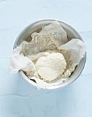 Homemade cream cheese in a muslin cloth (seen from above)