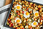 Oven-baked sweet potatoes and eggs with pepper, courgette, black beans and sweetcorn