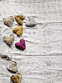 Garland of hand-sewn fabric hearts on white fabric