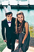A girl wearing an elegant black dress and a boy wearing a black suit and a crown