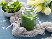 Green smoothie with spinach, banana, spirulina and chia seeds served in a mason jar