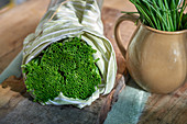 Chives wrapped in a towel on a wooden board