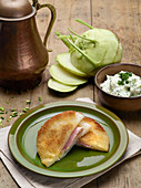 Breaded cabbage slices stuffed with ham and cheese, served with chive cream