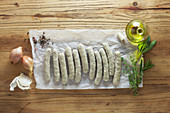Raw sausages with ingredients on paper