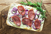 Tarte flambée with salami and red onions