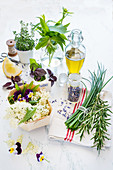 Frische Kräuter, Essblüten und Olivenöl