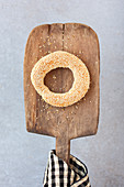 A sesame seed ring on a wooden paddle