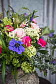 Bunter Frühlingsstrauß mit blauen, rosafarbenen und grünen Blumen