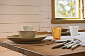 Crockery, cutlery and glasses in soft natural shades on table