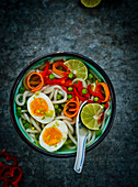 Udon noodle soup with vegetables, lime and eggs