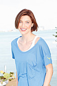 Rothaarige Frau in blauem T-Shirt mit weißem Top