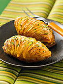 Hasselback-style baked potatoes with cheddar and parmesan cheese