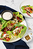 Quinoa und gebratenes Gemüse mit Tahini-Dressing im Salatblatt