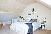 Simple attic bedroom with wood-clad walls