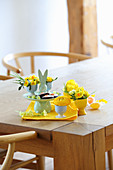 Hasen-Etagere und Eierbercher mit Frühlingsblumen auf Tisch