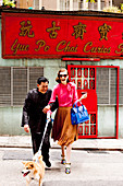 A couple with a dog outside a Chinese shop