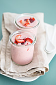 Yoghurt dessert with cream, fresh strawberries and strawberry jam