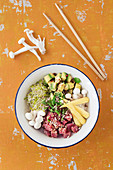 Poke Bowl mit Thunfisch, Avocado, Brokkolisprossen und Enoki-Pilzen auf Sushi-Reis (Hawaii)