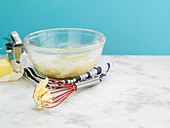 Cake batter in a glass bowl and on a whisk