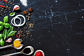 Various sauces in old metal spoons, fresh herbs and spices on dark vintage background with space for text
