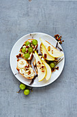 Tasty crostini with pear, cream-cheese, grapes, banana and nuts