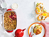 Frühstücksbuffet mit Erdbeer-Hafer-Crumble, Croissant mit Rührei, Schinken und Tomatenrelish, Papaya-Bowls mit Kokosjoghurt und Mango