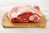 Raw lamb shoulder on a chopping board