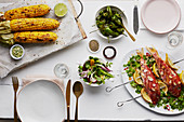 Grilled red snapper with corn cobs and a vegetable salad