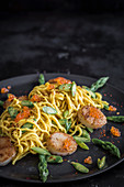 Spaghetti with saffron sauce, scallops, trout caviar and green asparagus