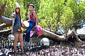 Zwei junge Frauen mit Discokugeln am Baumstamm
