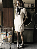 Junge Frau in hellem Kleid im Waschsalon