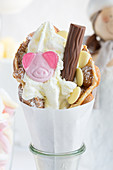 A bubble waffle with a gummy pig sweet, white chocolate and a chocolate bar