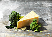 A piece of cheddar with broccoli heads