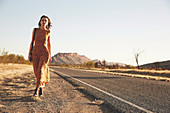 A young woman wearing a long, desert print dress