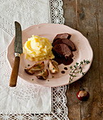 Roast venison with mashed potatoes, mushrooms, and dark sauce