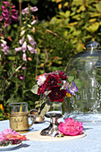 Blumensträußchen im Glaspokal auf dem Gartentisch