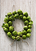 A wreath of brussels sprouts on a white wooden background