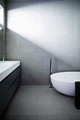 Designer bathroom with bathtub and gray tiles