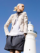 A blonde woman wearing a light top and a dark grey skirt