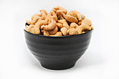 Roasted and salted cashews in a black bowl